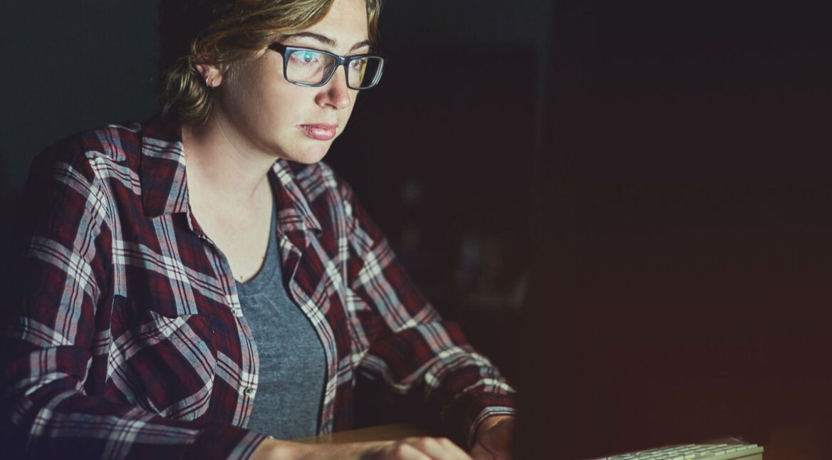 Junge Frau aktiviert an ihrem Windows-PC den Dark Mode.