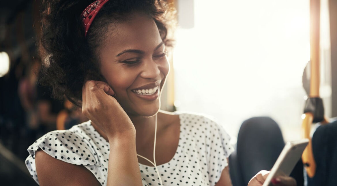Junge Frau stellt die maximale Lautstärke ihres iPhones ein.