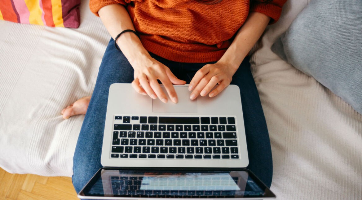 Junge Frau startet am Laptop einen Gruppenchat.