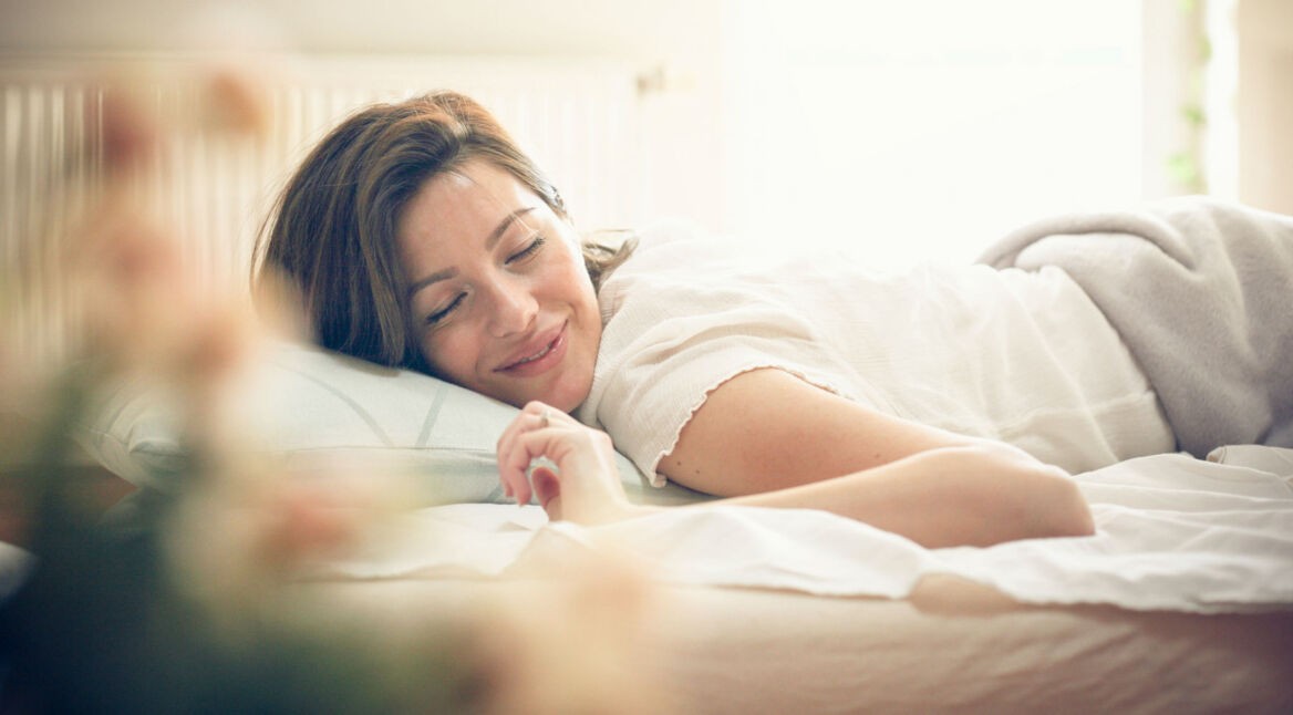 Junge Frau schläft im Bett.