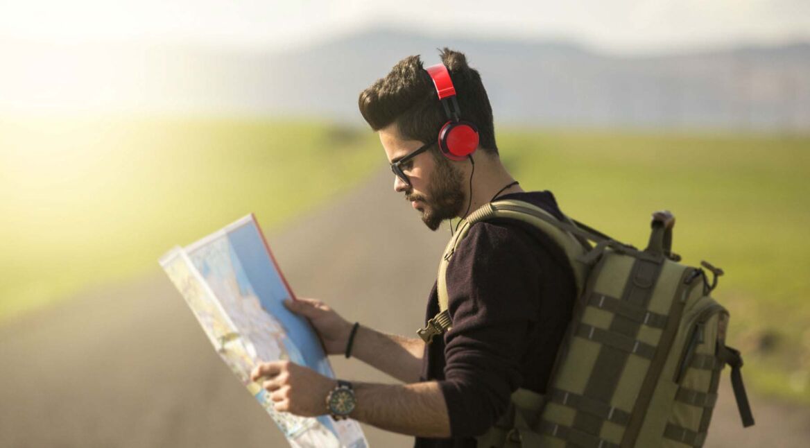 Junger Mann hört während der Navigation Musik.