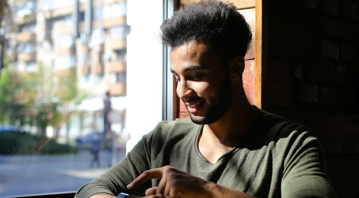 Junger Mann scrollt durch seine Benachrichtigung auf der Smartwatch.