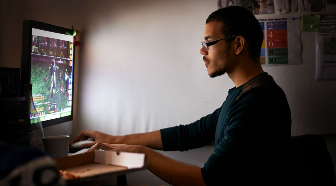 Junger Mann zockt ein PC-Spiel am Computer.