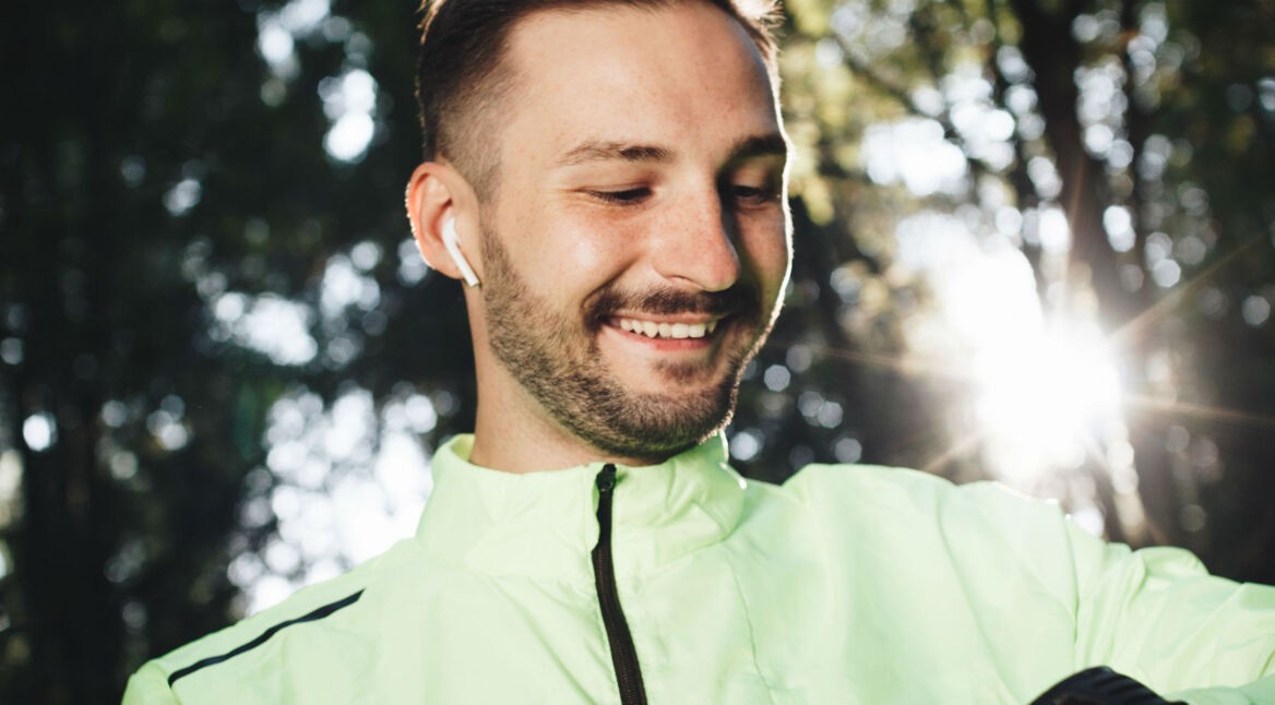 Junger Mann hört sein Audible-Hörbuch über die Smartwatch.