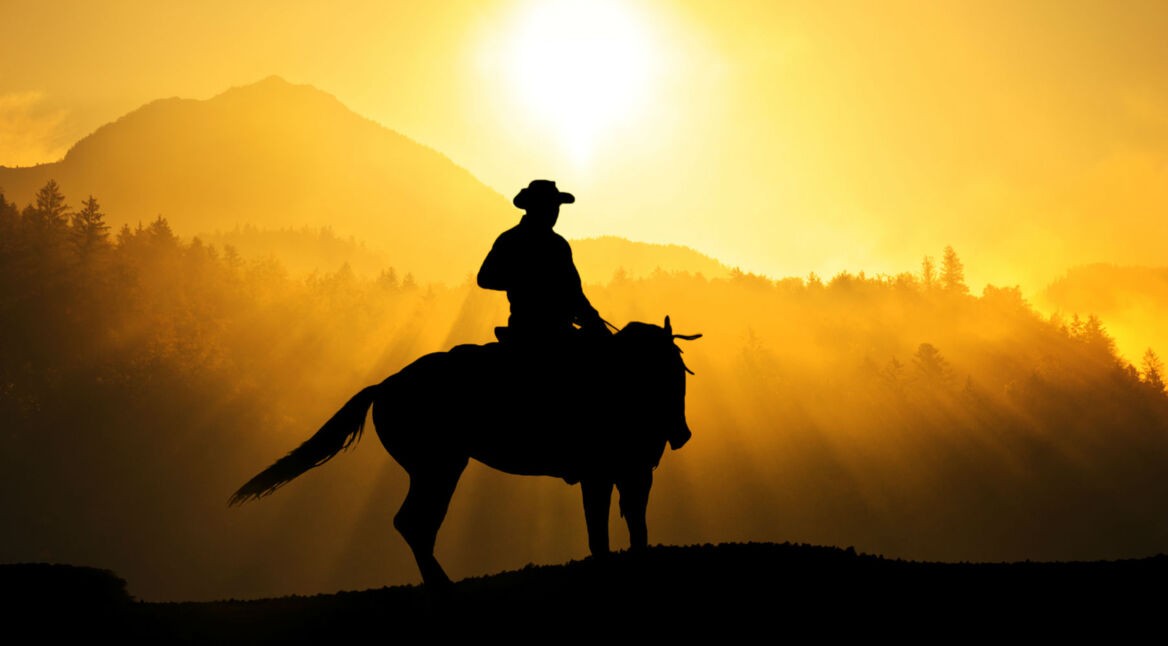 Junger Outlaw reitet auf dem Pferd durch den Wilden Westen.