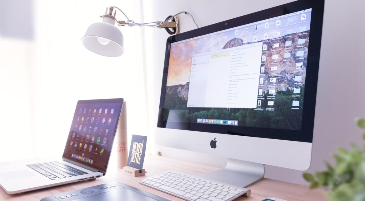 Schreibtisch mit Mac und MacBook