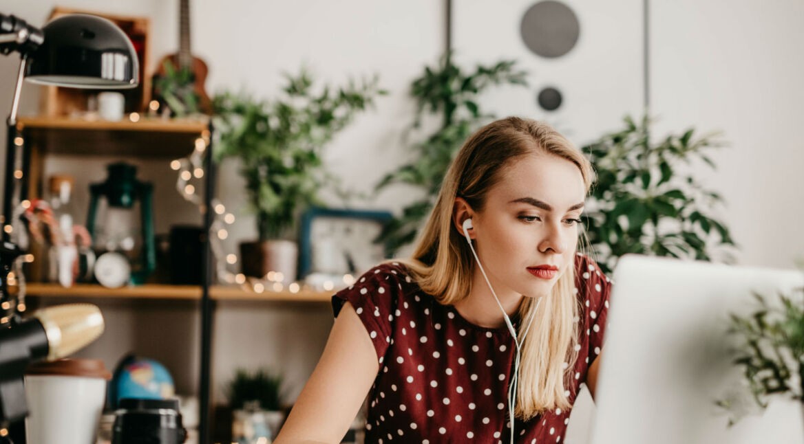 Frau erstellt Youtube-Banner am Laptop.