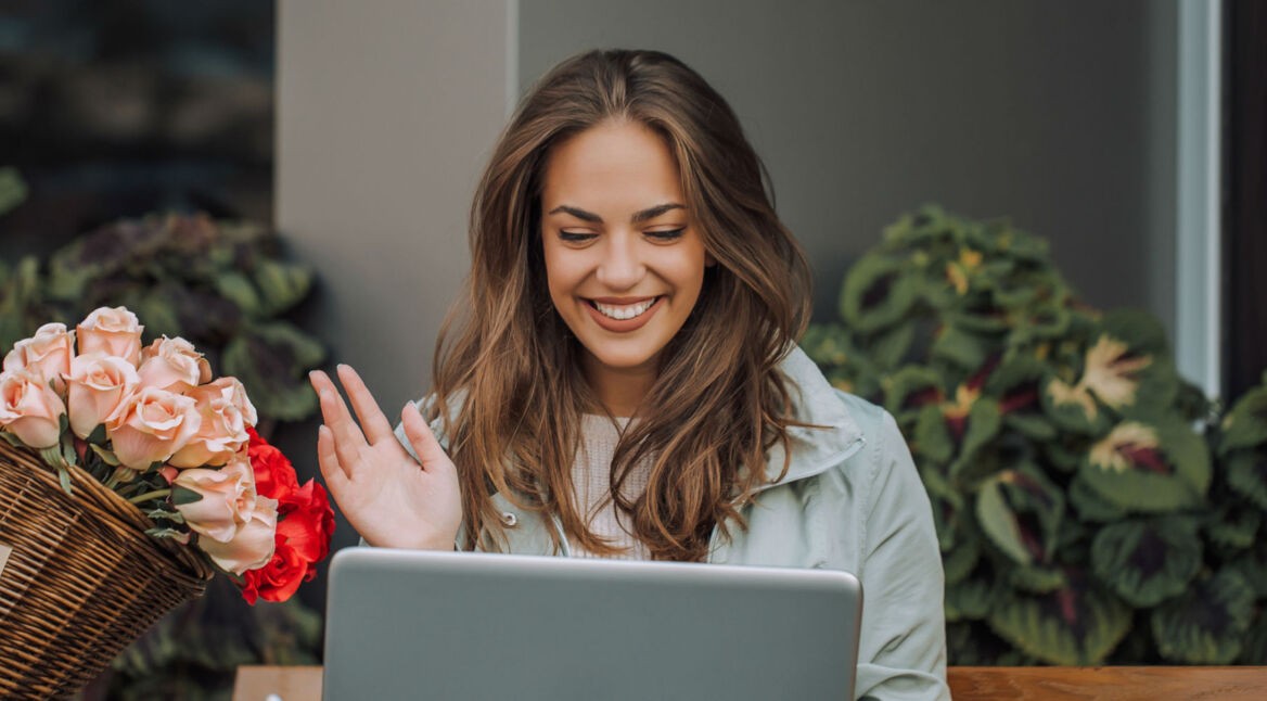 Junge Frau nutzt die Webcam für Videotelefonie mit dem Laptop.