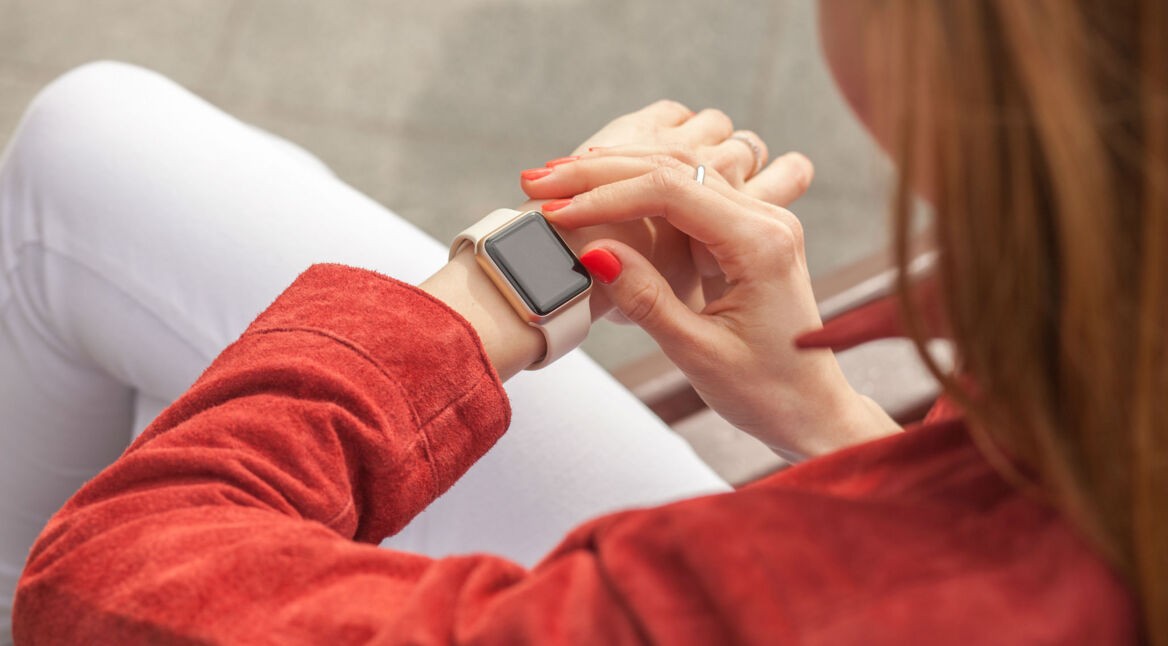 Junge Frau schaut auf ihr Apple-Watch-Display.