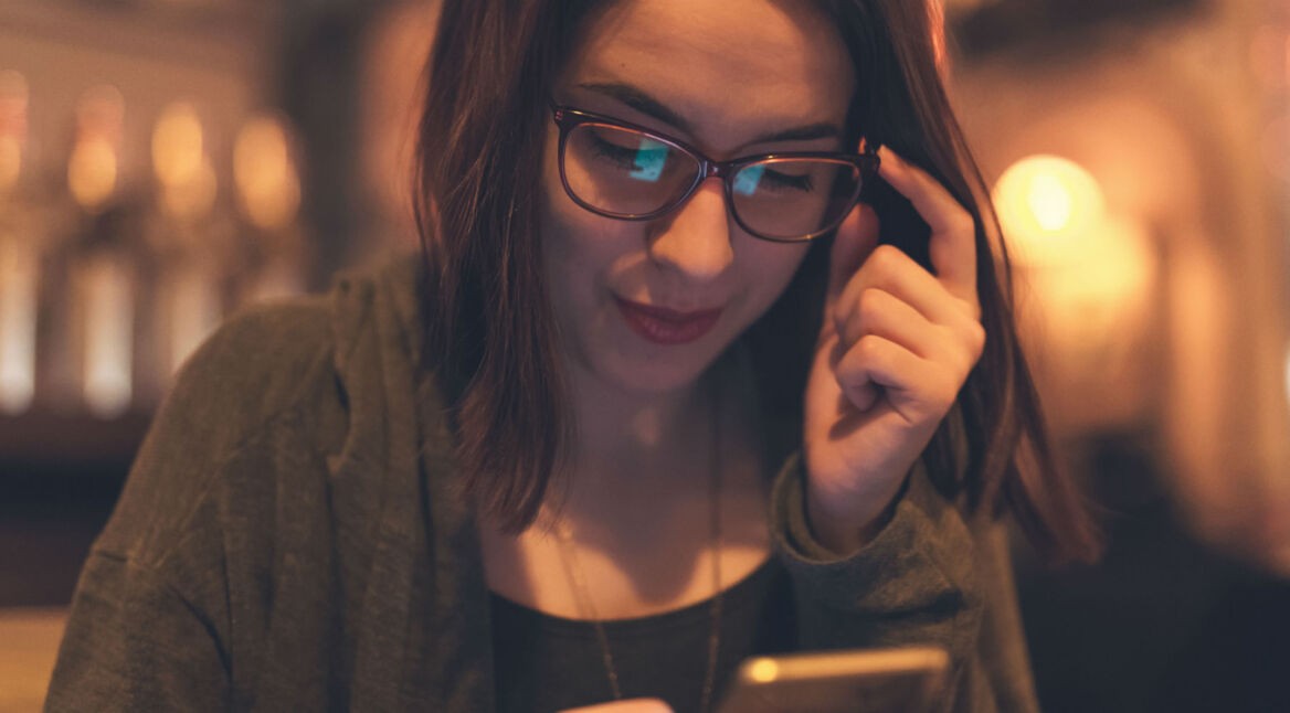 Frau richtet für Siri am Smartphone einen Kurzbefehl ein.