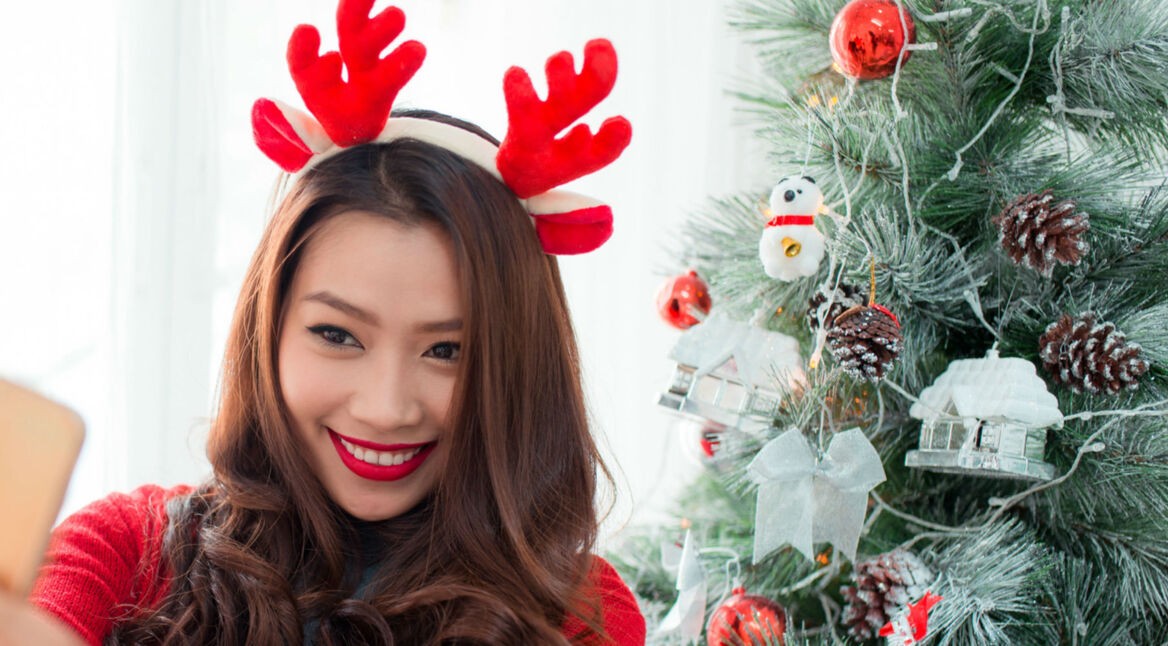 Junge Frau nimmt Video mit ihrem Memoji am Smartphone auf.