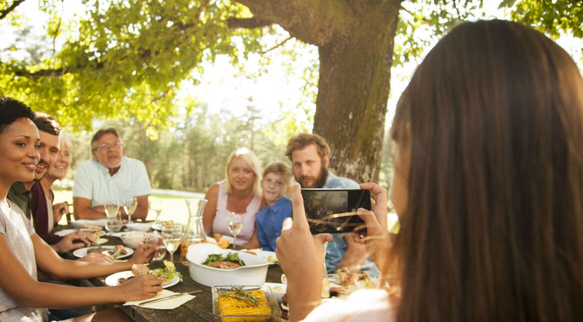 Junge Frau nimmt ein Gruppenfoto auf.