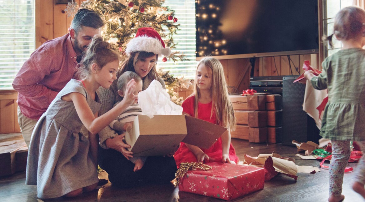 Kinder packen Tech-Spielzeug an Heiligabend aus.