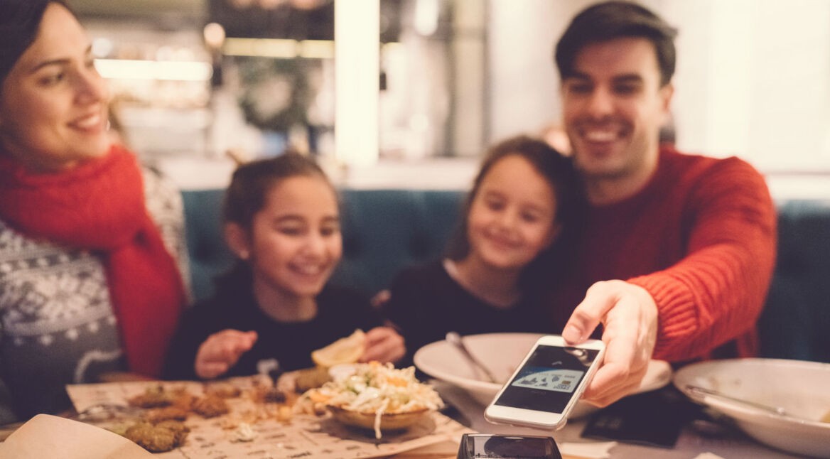 Mann bezahlt bargeldlos mit Apple Pay für das Essen.