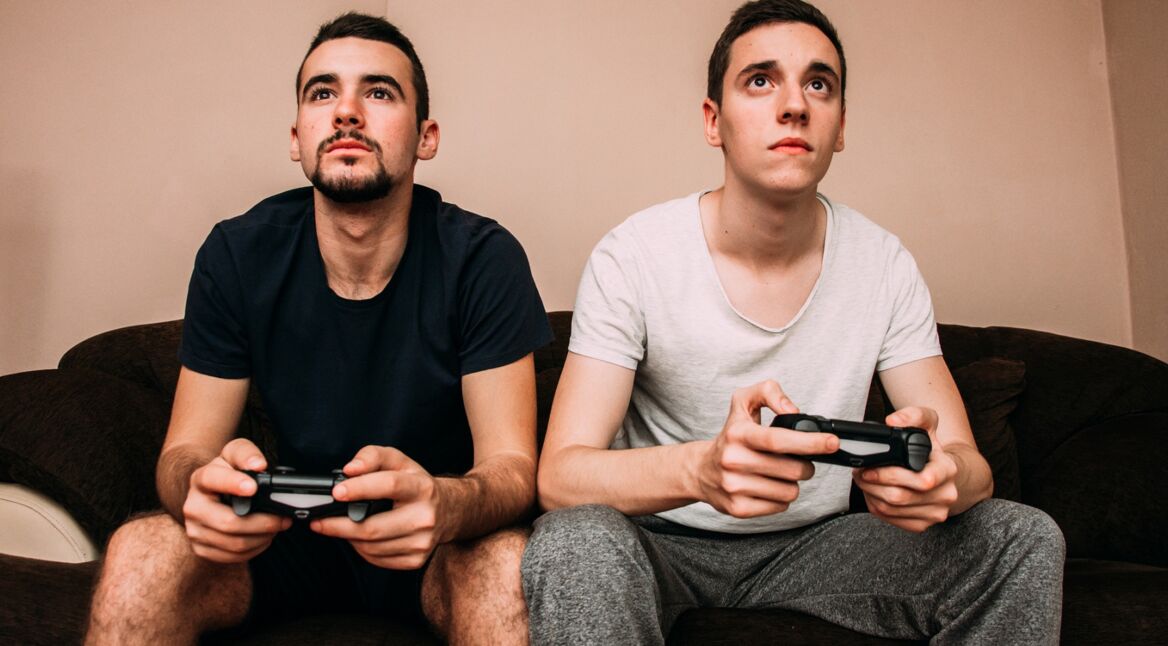 Zwei junge Männer spielen Monster Hunter: World