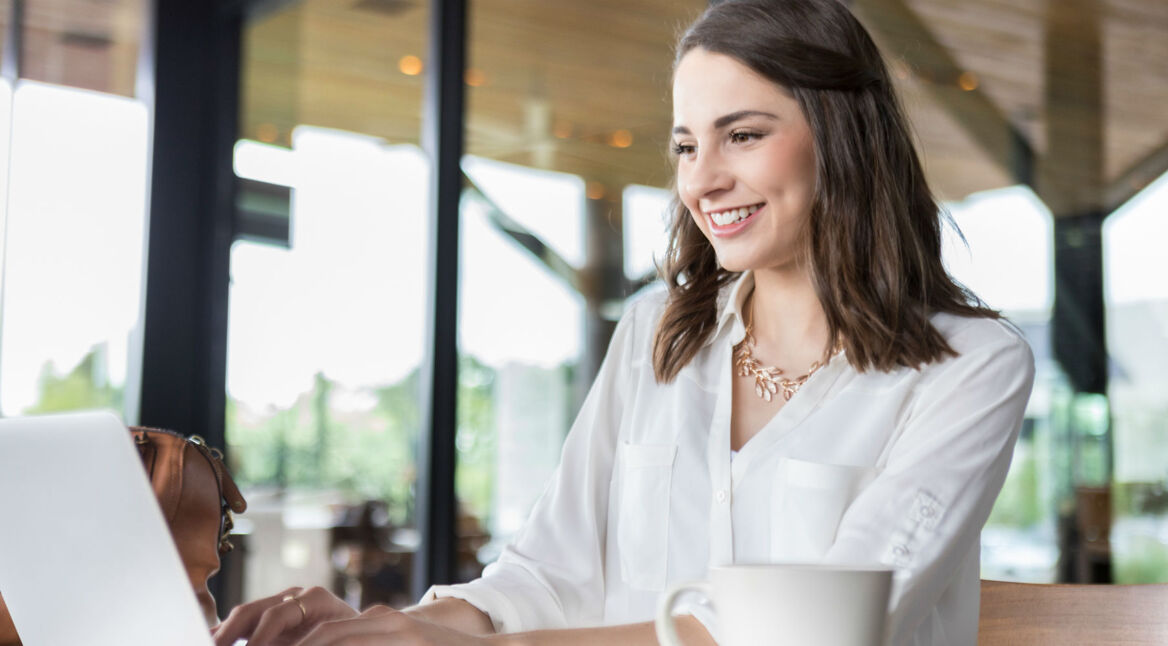Junge Frau bearbeitet ihre Videos am MacBook.