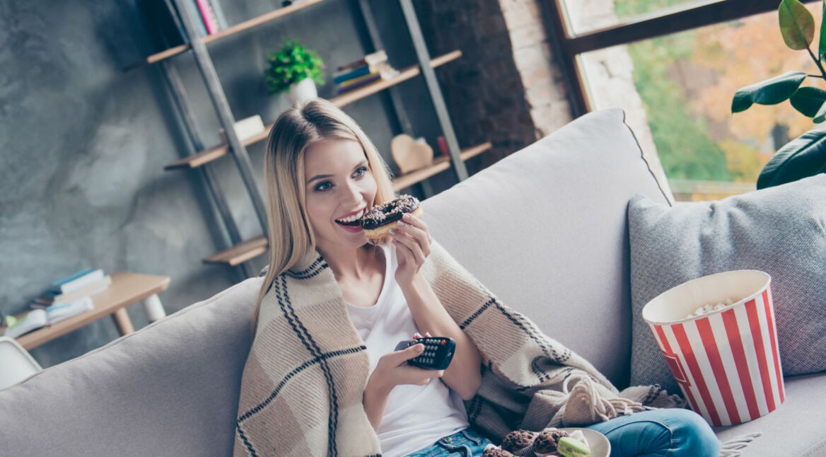 Frau steuert mit Alexa-Fernbedienung den Amazon Fire TV.