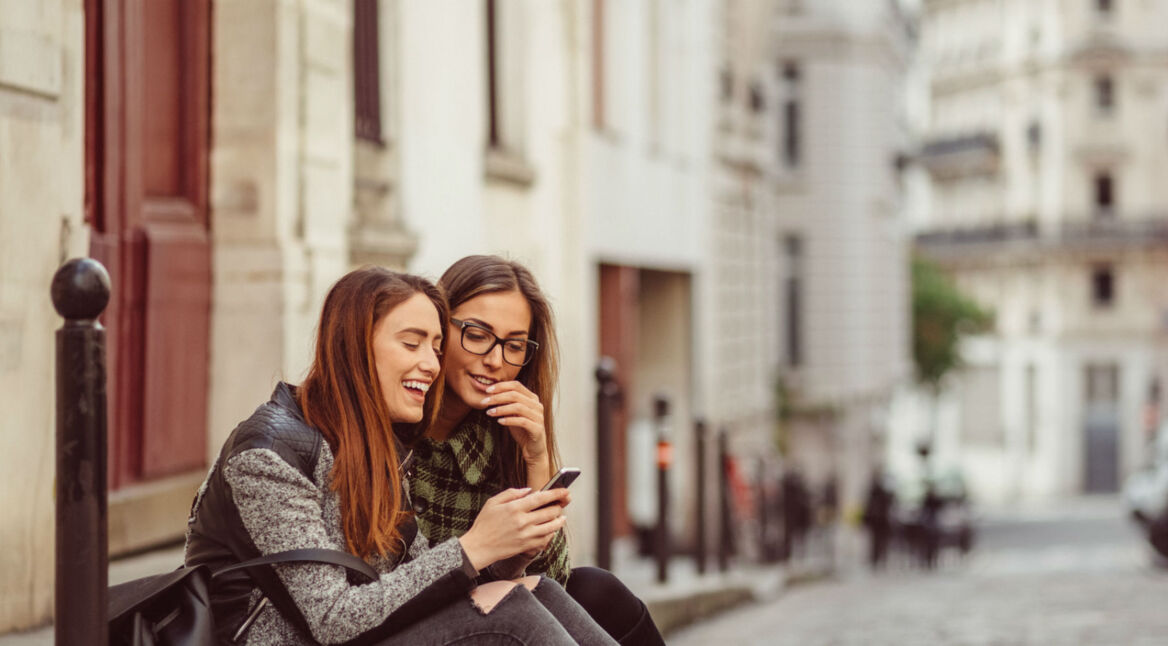 Freundinnen spielen am Smartphone ein Mobile Game.