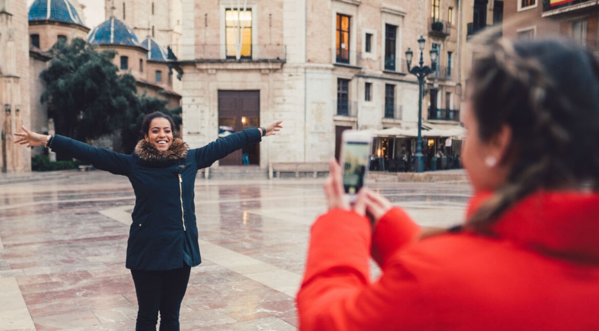 Junge Frau macht ein Foto mit ihrer iPhone-Kamera.