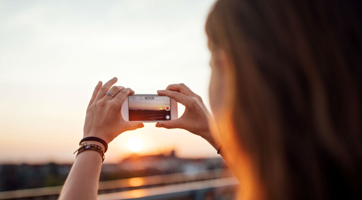 Junge Frau fotografiert mit dem Smartphone für Instagram.