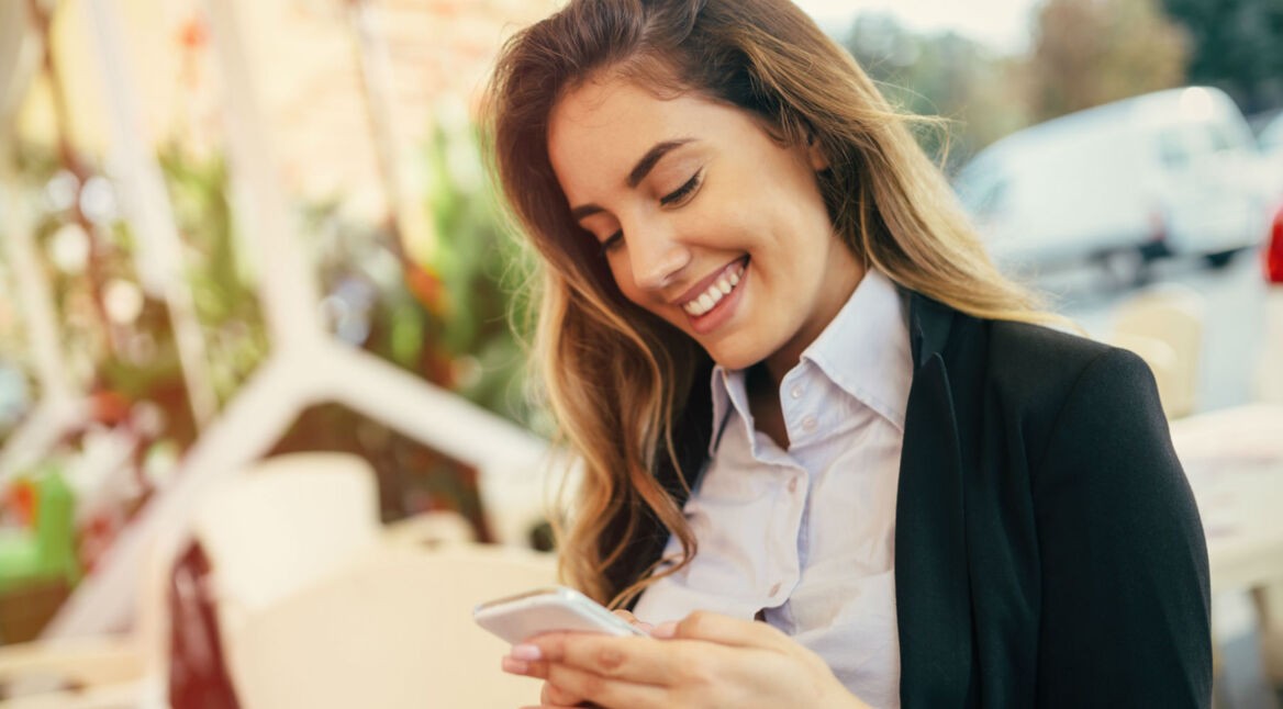 Junge Frau sieht die chronologische Twitter-Timeline auf ihrem Smartphone ein.