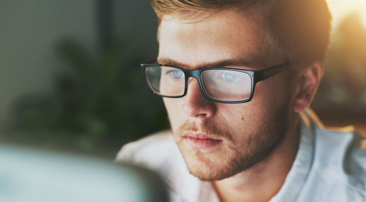 Junger Mann löst am Computer seine Windows-10-Probleme.