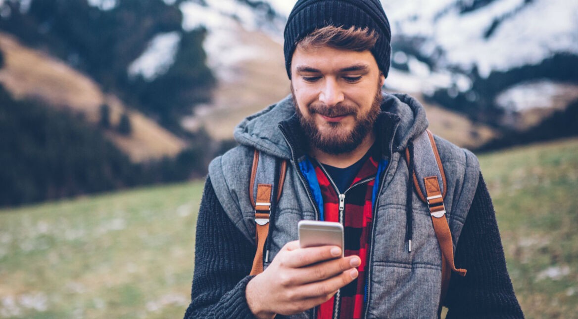 Junger Mann nutzt den Facebook Messenger am Smartphone.