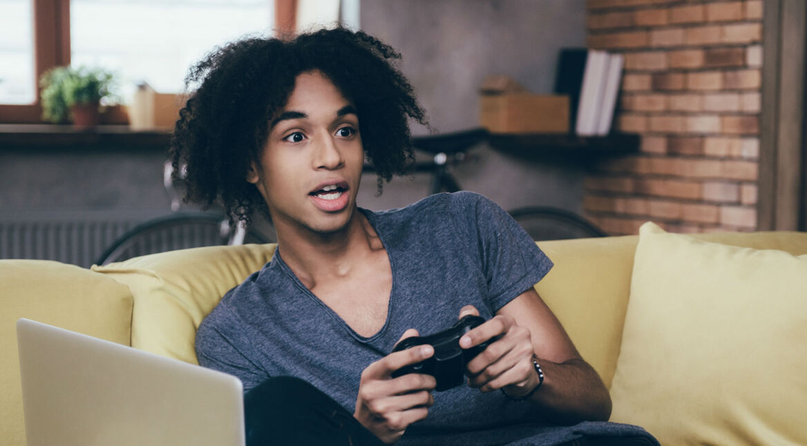 Junger Mann spielt Jump Force mit seinem Controller.