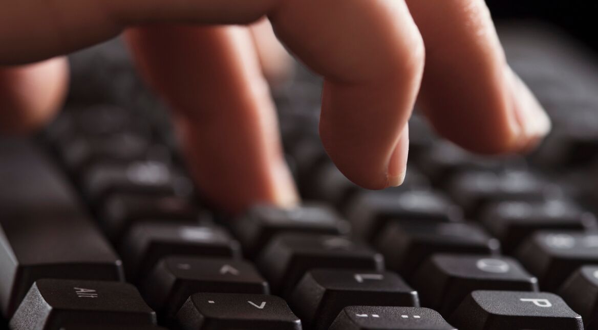 Weibliche Hand tippt Sonderzeichen