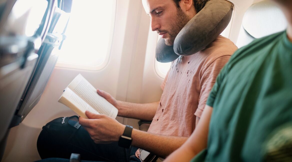 Mann mit Apple Watch im Flugzeug