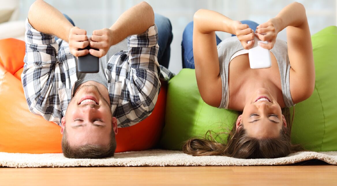 Junges Pärchen spielt Brettspiel-Apps gegeneinander