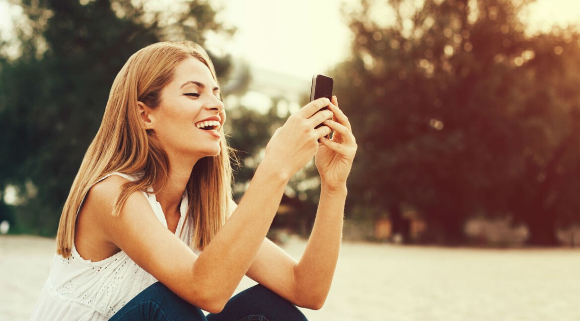 Junge Frau nutzt Telegram am Smartphone.