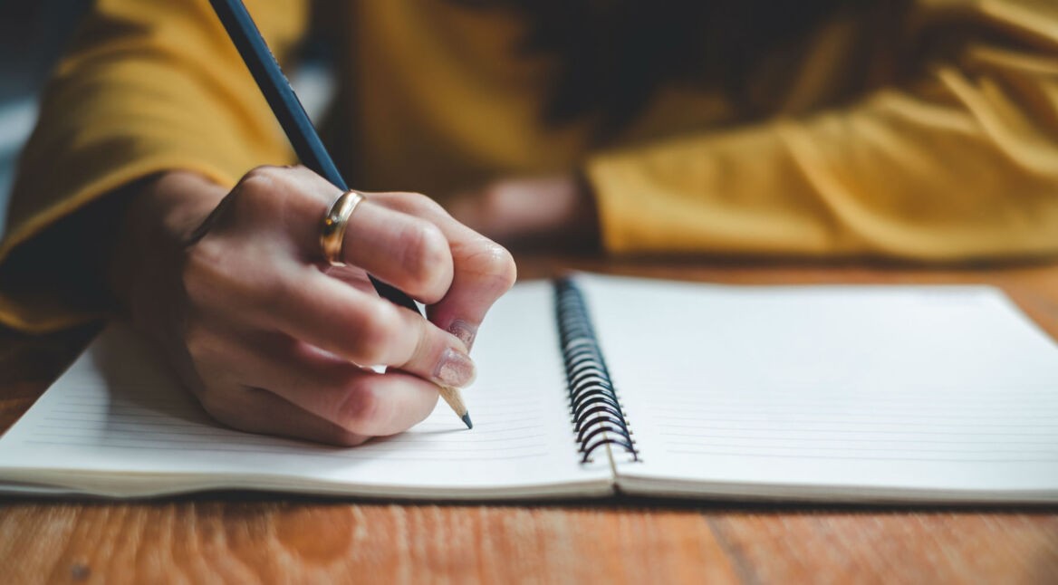 In ein Notizbuch schreiben.