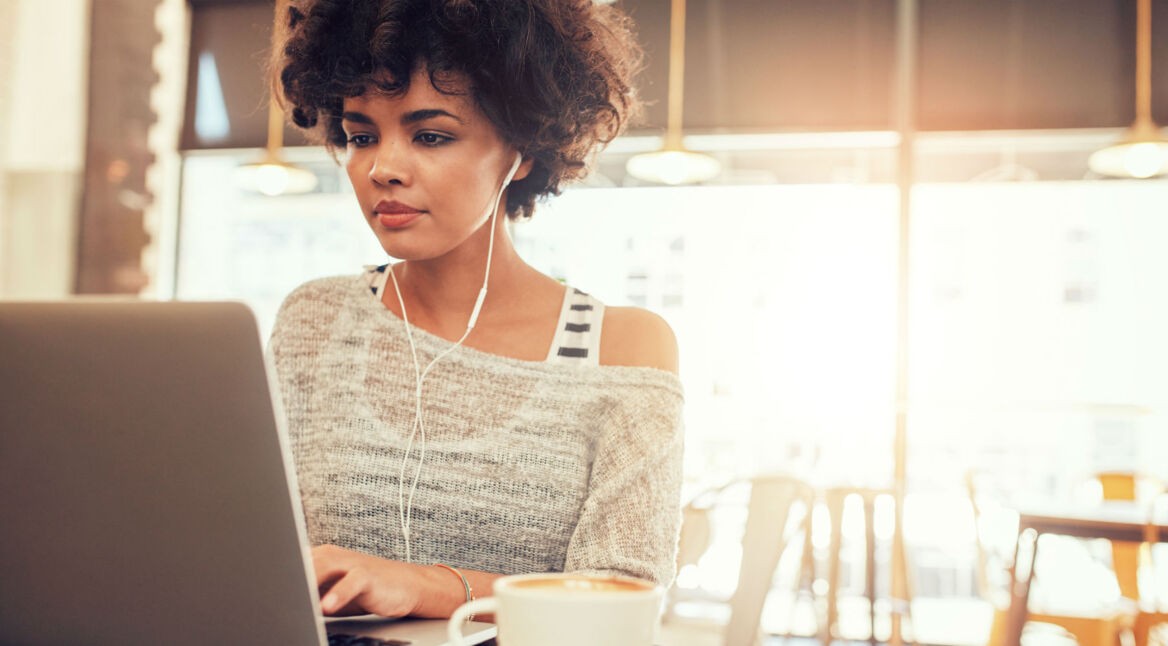 Junge Frau verwendet Kodi auf ihrem Laptop.