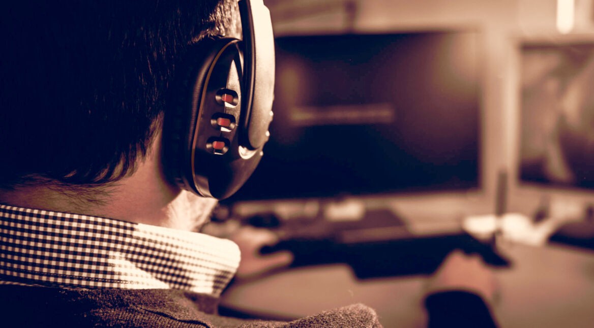 Junger Mann spielt Spiel am PC.