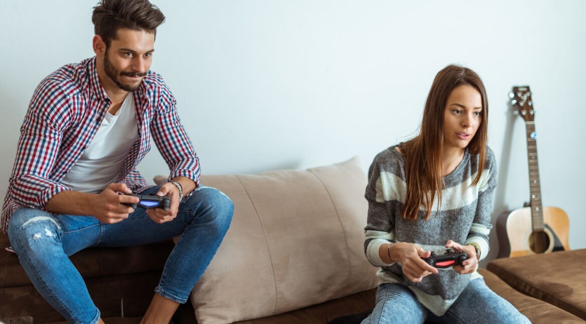 Ein junges Pärchen spielt auf der PlayStation