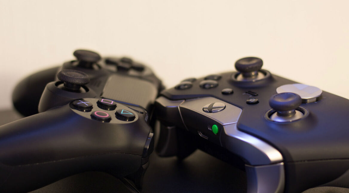 Ein PS4- und Xbox-One-Controller liegen auf dem Tisch.