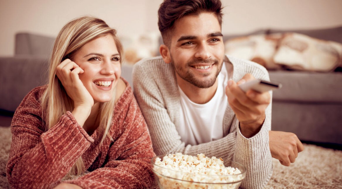 Junges Paar schaut sich eine Amazon-Prime-Video-Serie auf dem Fernseher an.