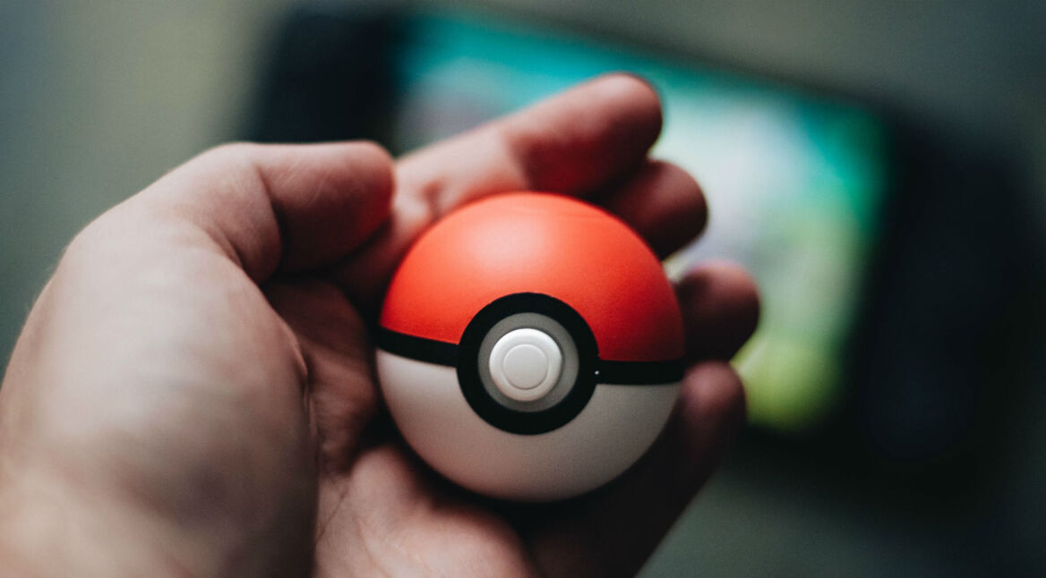 Mensch hält einen Pokéball in der Hand.