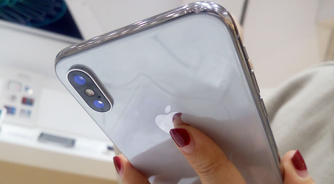 Frau hält iPhone X in ihrer Hand.