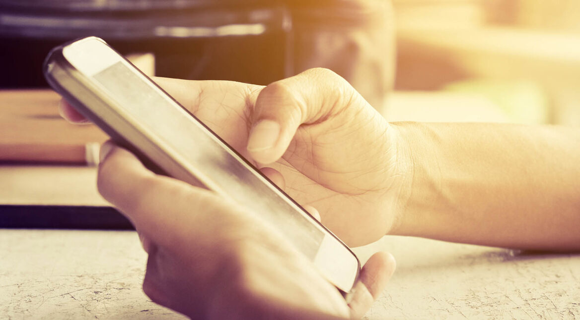 Auf dem Display des Smartphones mithilfe von SwiftKey etwas eintippen.