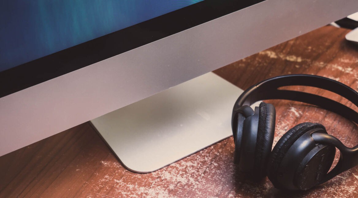 Bluetooth-Kopfhörer liegt neben einem Mac.