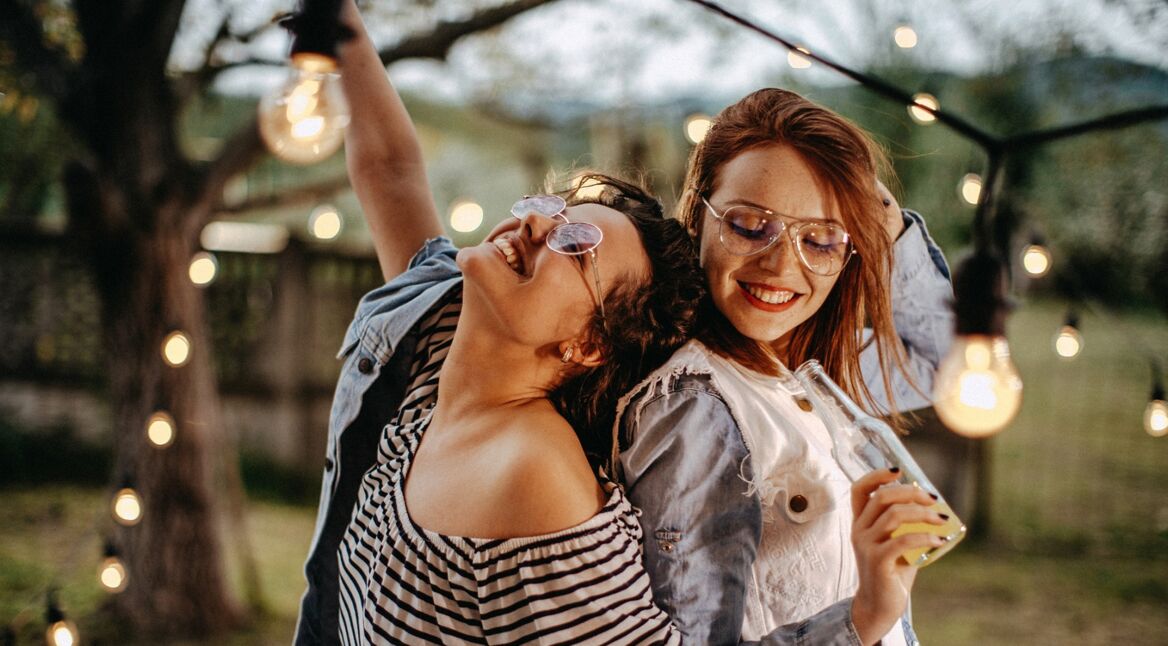 Zwei junge Frauen hören draußen Musik über den HomePod