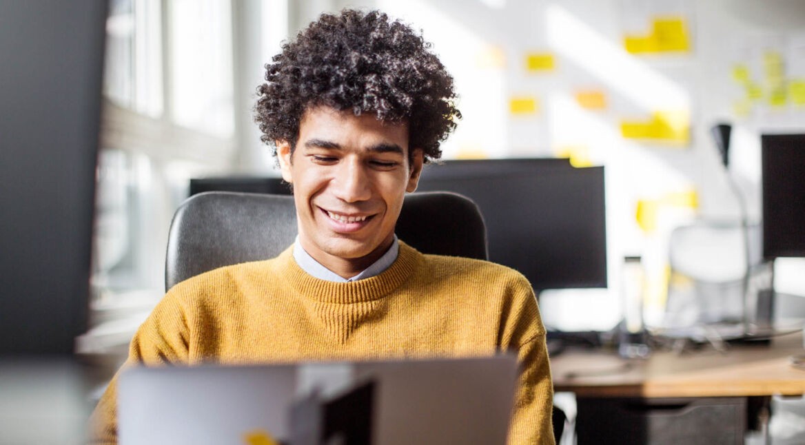 Junger Mann nutzt iTunes problemlos am Computer.