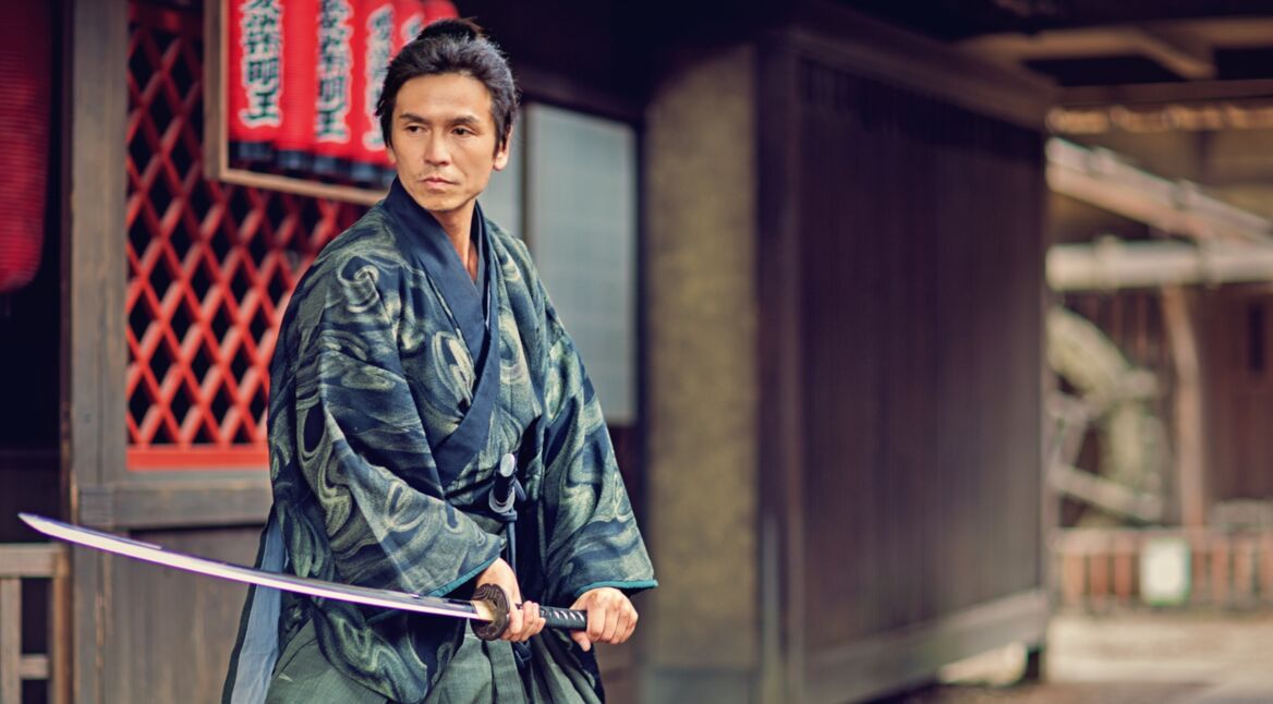 Mann posiert mit Katana