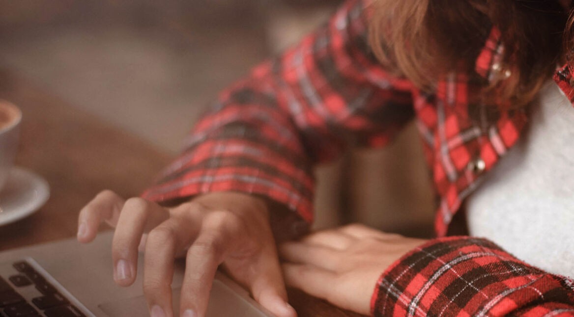 Junge Frau teilt am Laptop den Bildschirm.
