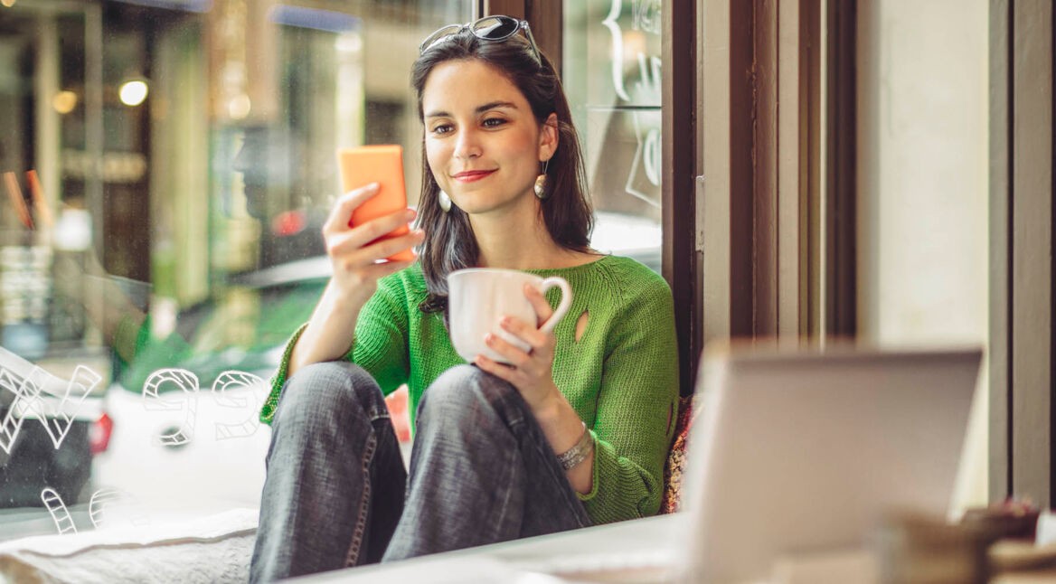 Junge Frau ändert am iPhone die iTunes-Bezahlmethode zu PayPal.