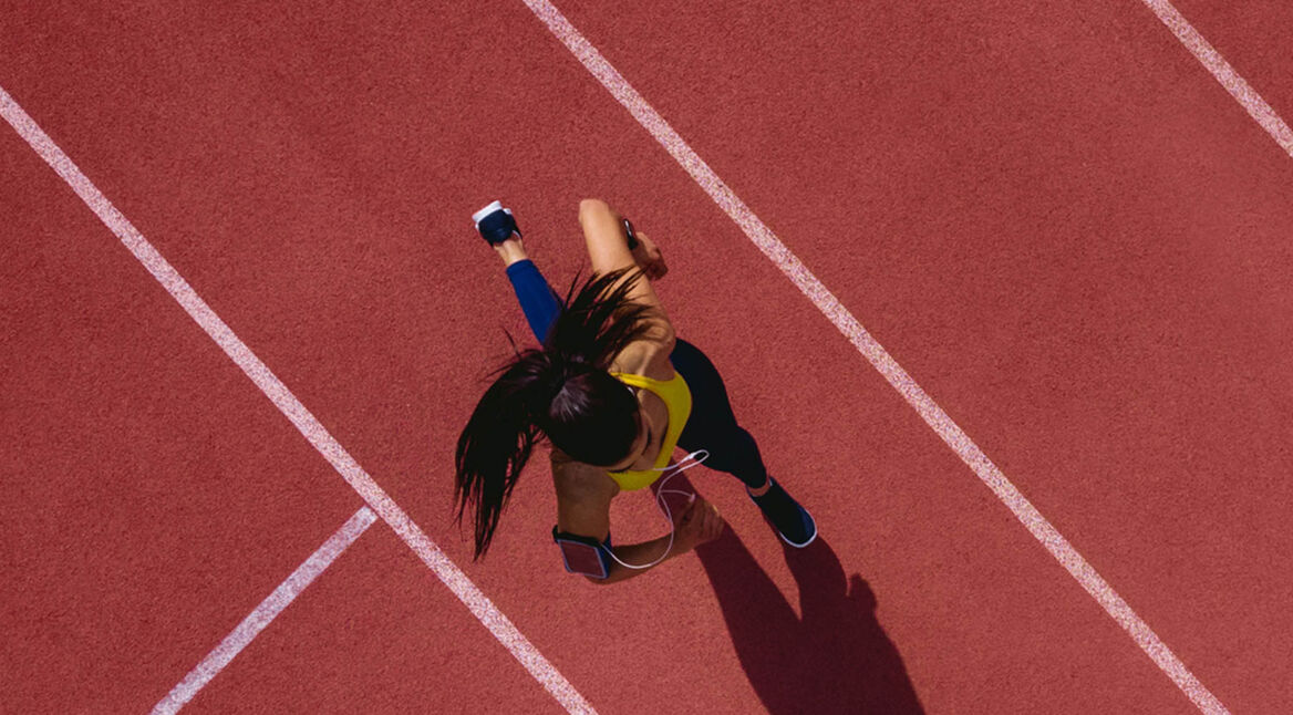 Junge Frau läuft eine Runde und zeichnet dies mit ihrem iPhone auf.