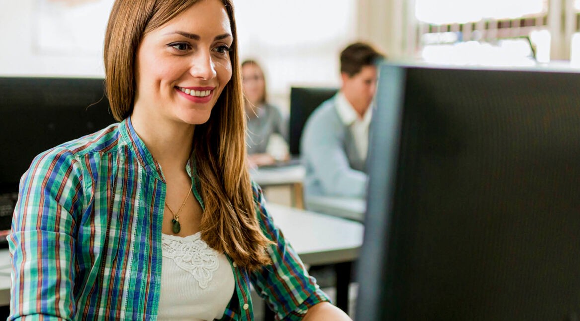 Junge Frau startet am PC den Windows-Task-Manager.