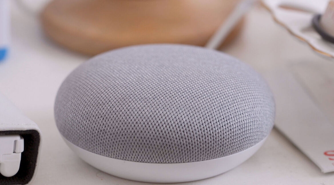 Der Musik abspielende Google-Home-Lautsprecher steht auf einem Tisch.